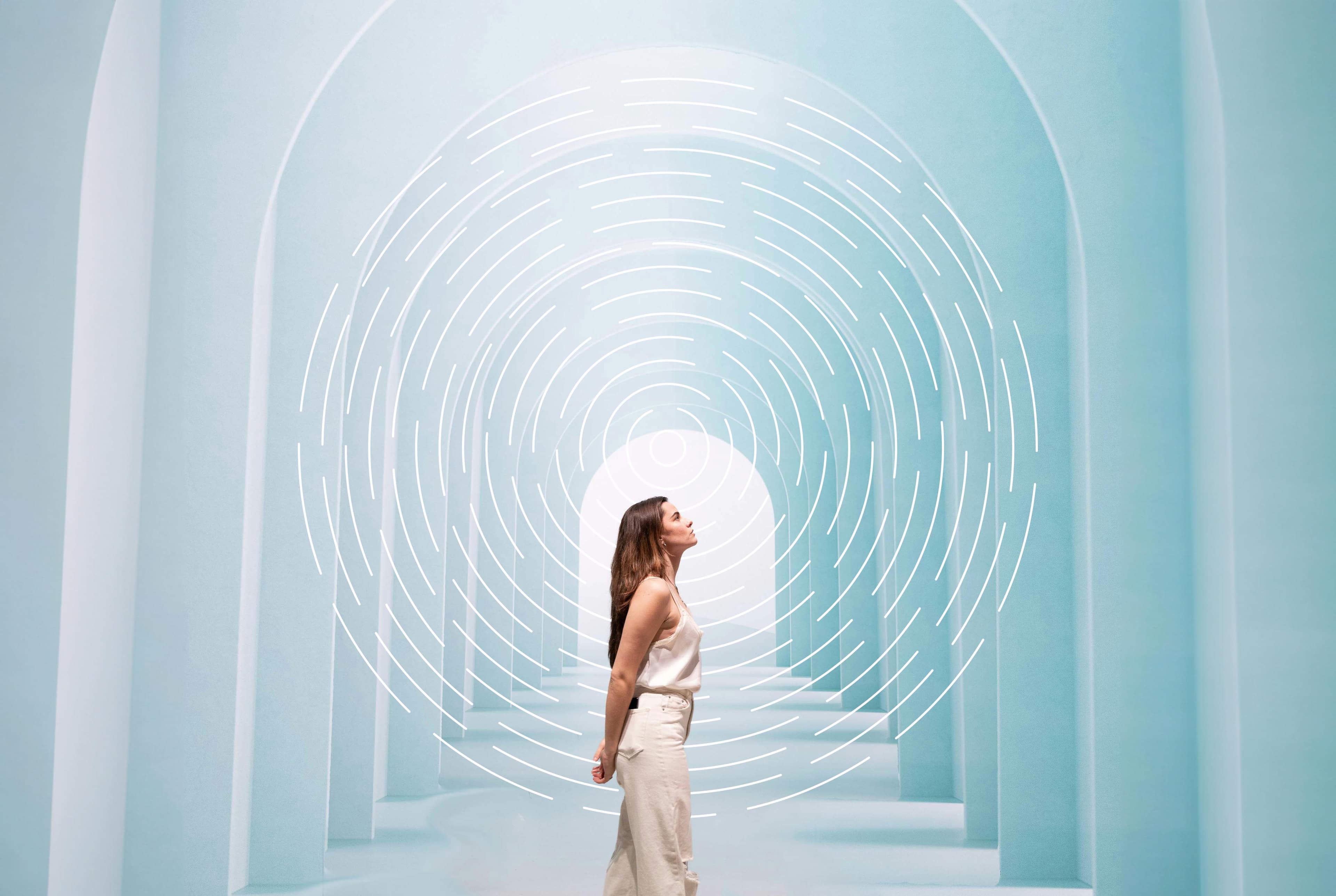 image of a woman looking down an arched hallway